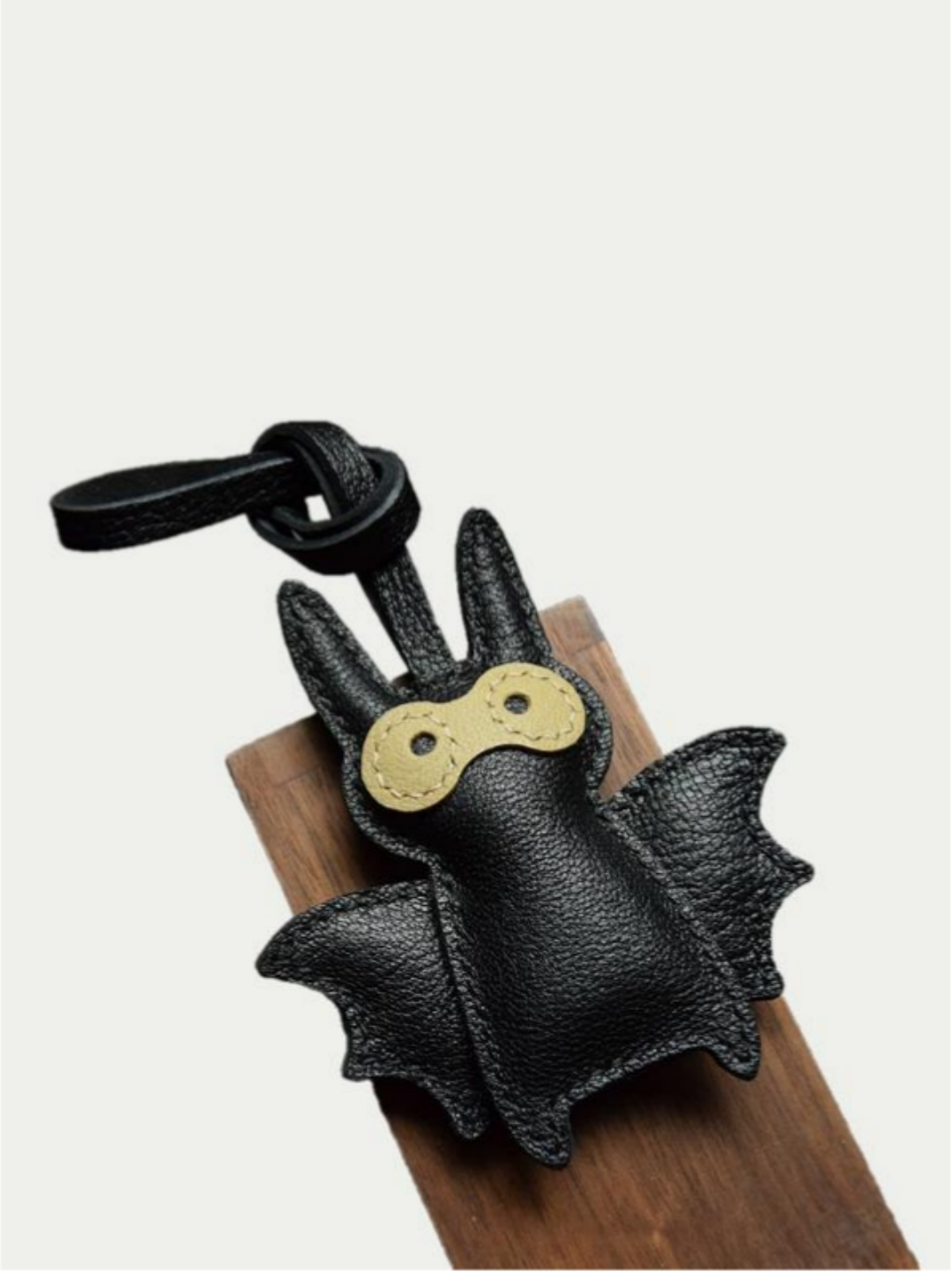 Close-up detail of the handmade bat charm showing the fine craftsmanship