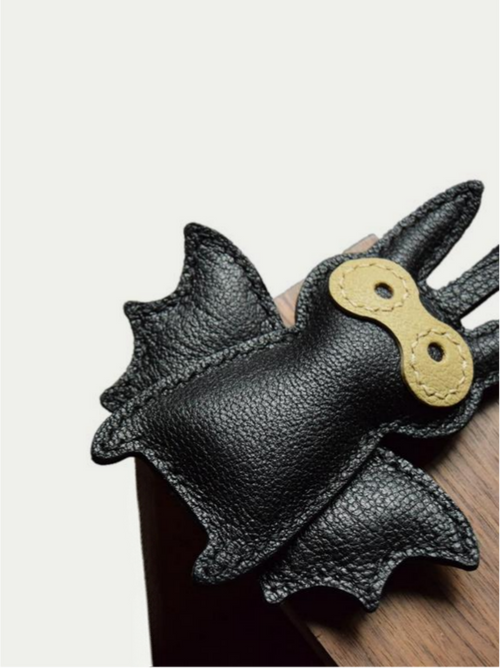 Close-up detail of the handmade bat charm showing the fine craftsmanship