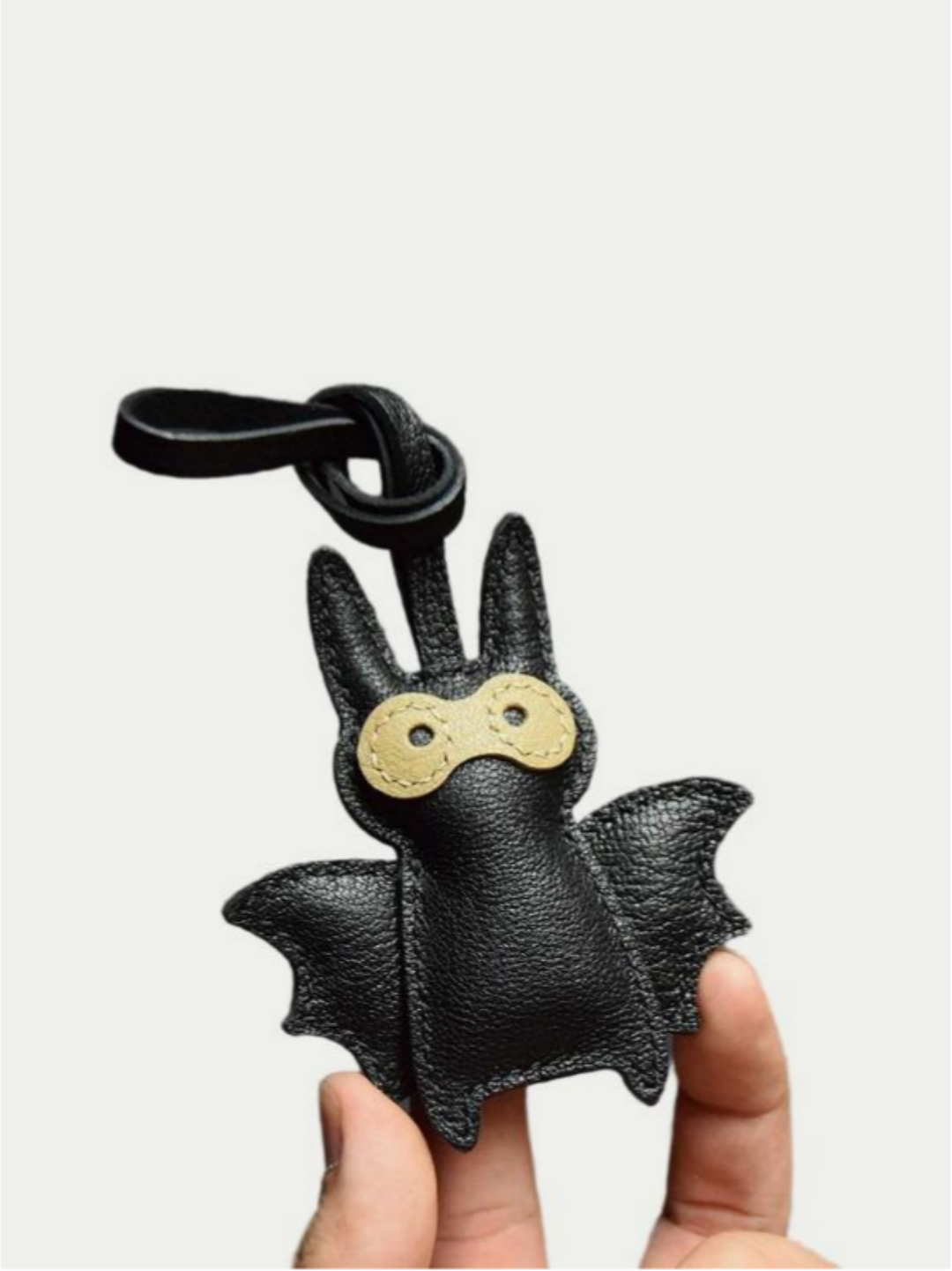 Close-up detail of the handmade bat charm showing the fine craftsmanship